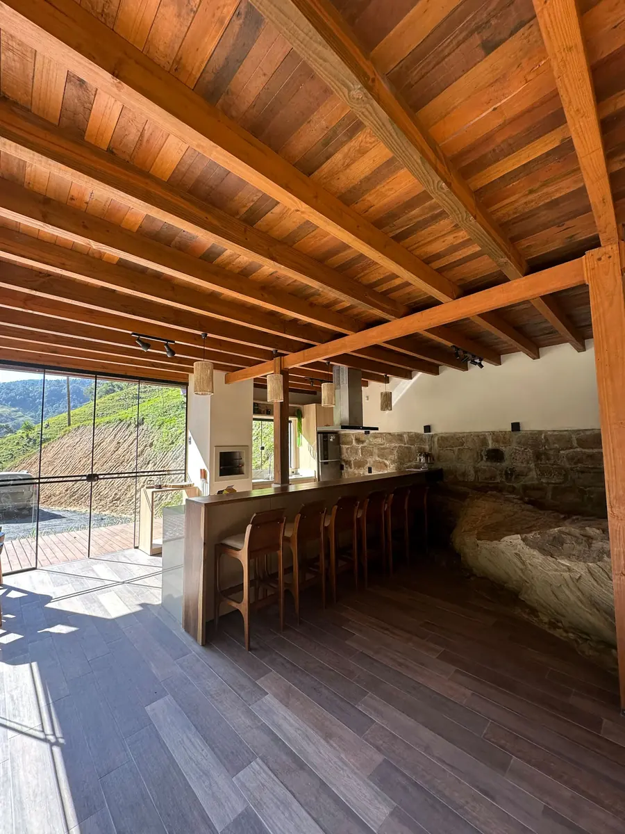 Cozinha integrada com teto de madeira e vista para o morro