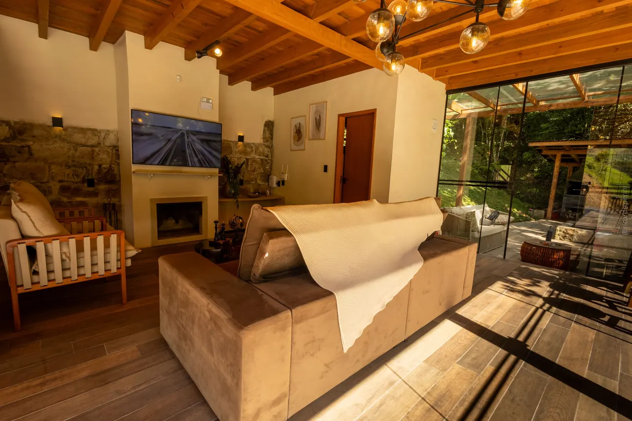 Sala com lareira e sofá, com vista para a área externa