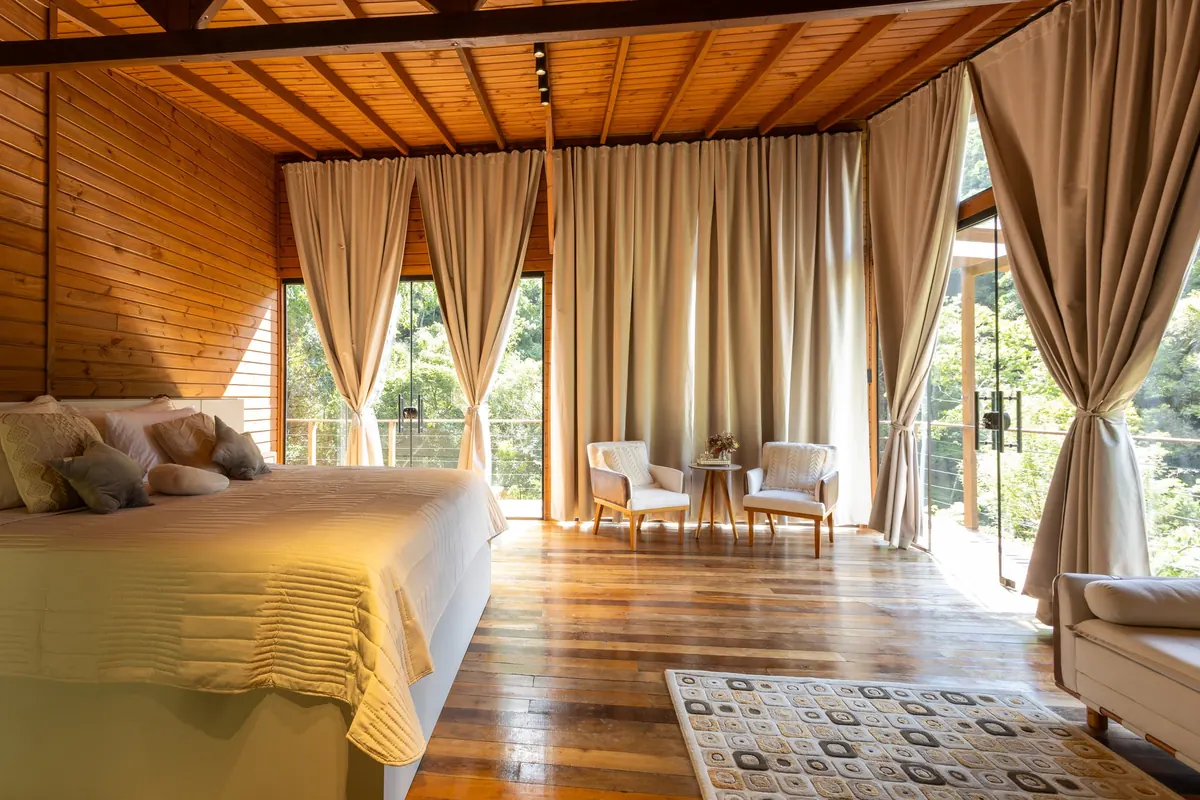 Segunda suíte com cama king e cortinas abertas